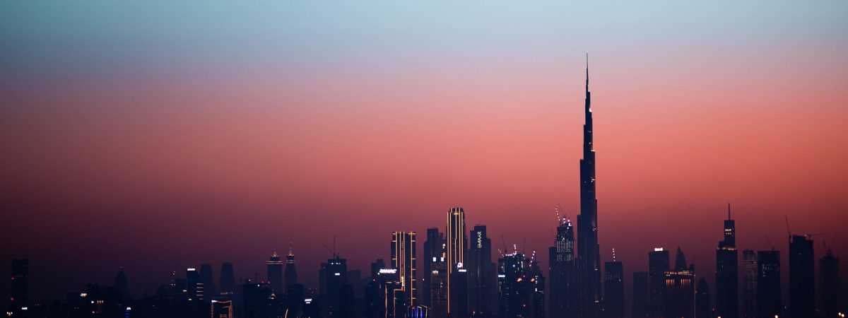 Dubai skyline at sunset with the Burj Khalifa towering over the city.